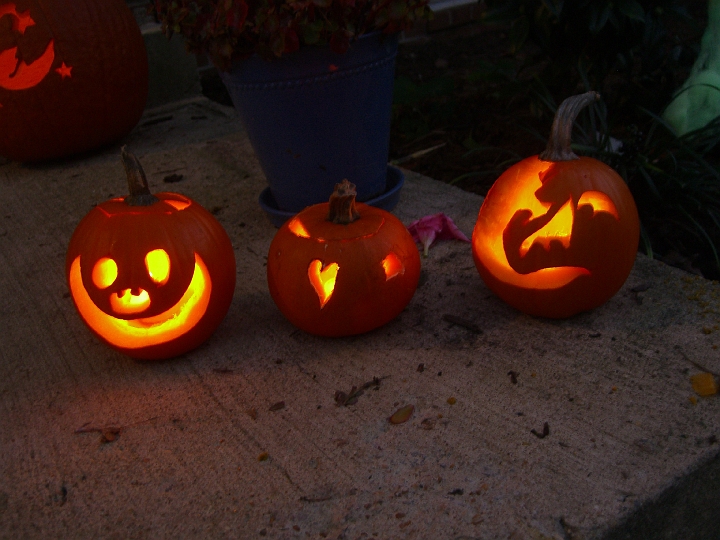 CIMG2727.JPG - Small Cox Farms pumpkins. Smiley face (Neva's idea), small heart and star (this was a very hard pumpkin), half-rotten pumpkin carved into zombie melting face (David's idea).